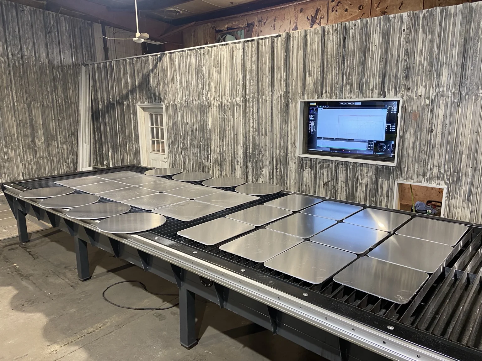 Metal fabrication table in the shop with steel parts laid out for cutting